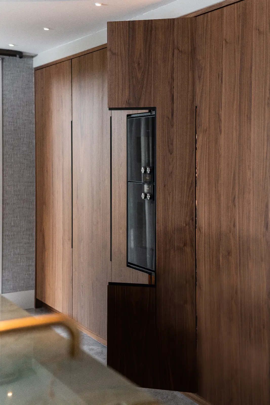 Een ingebouwde oven is naadloos geïntegreerd in een wand van slanke, moderne houten kasten, waardoor de hedendaagse keuken een luxe villa interieur raffinement krijgt.