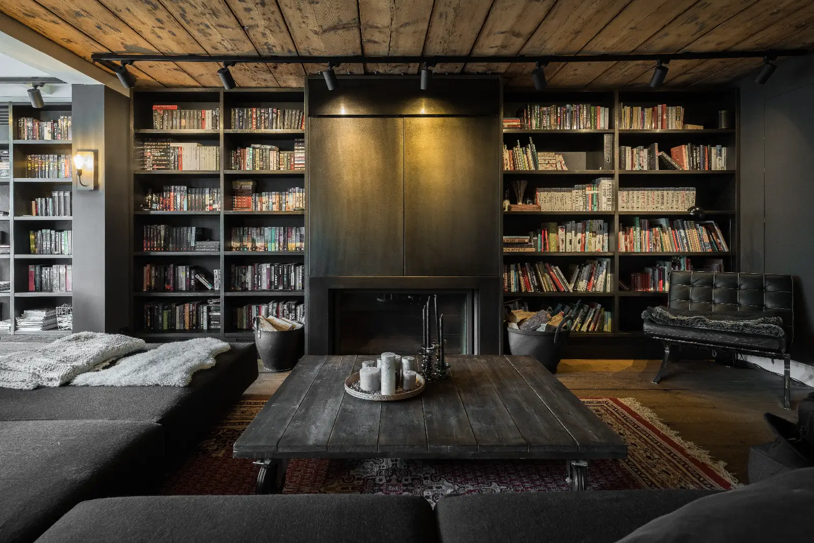 Bibliotheekstijl woonkamer met haard en boekenwand, ontworpen door interieurontwerper uit de buurt van Amsterdam.