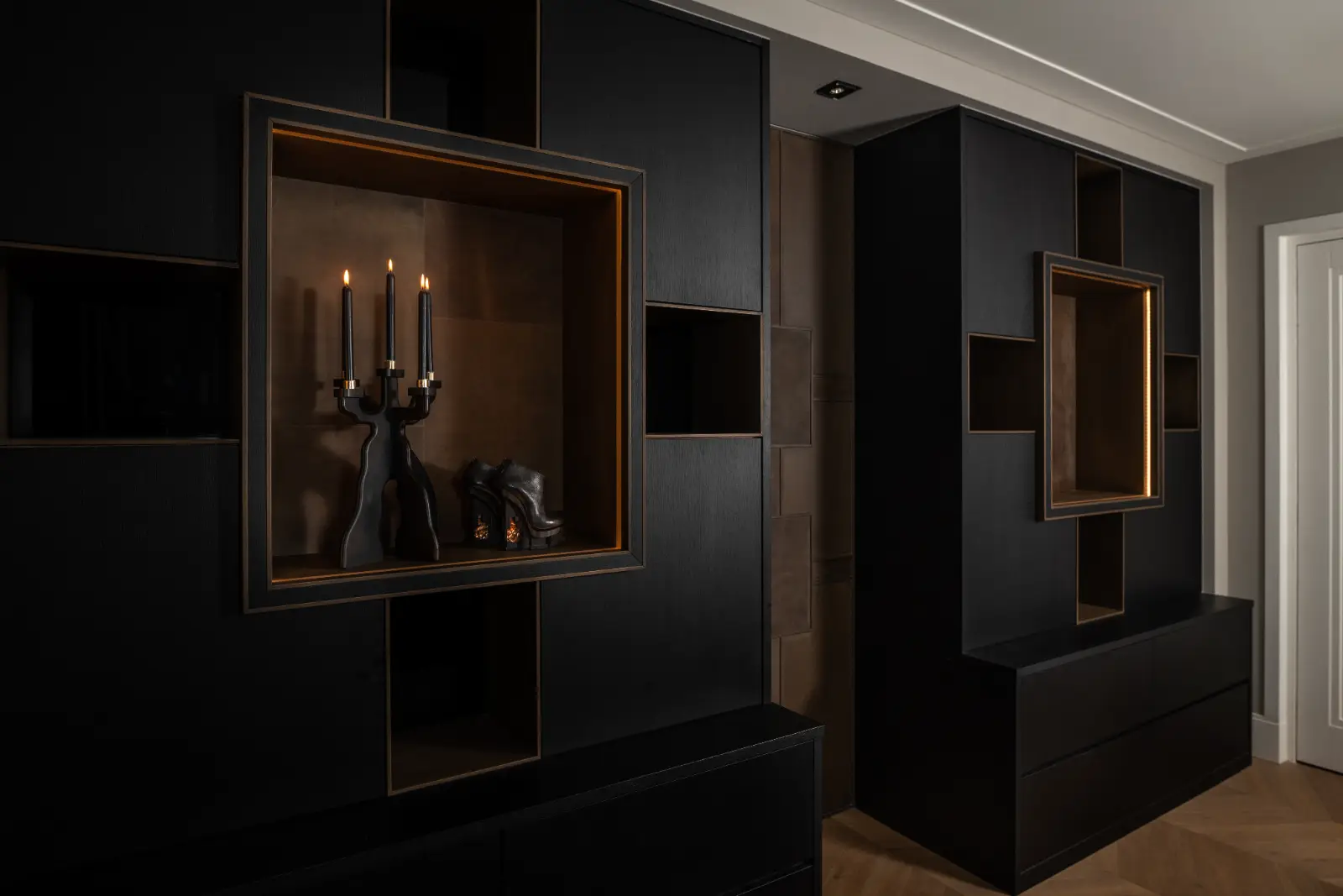 Luxe maatwerk interieur met zwarte kasten en interieur maatwerk in warme houttinten.