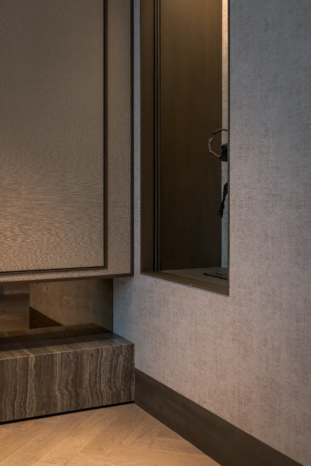 Interieur maatwerk in een minimalistische hal met op maat gemaakte wandpanelen, luxe materialen zoals marmer en stof